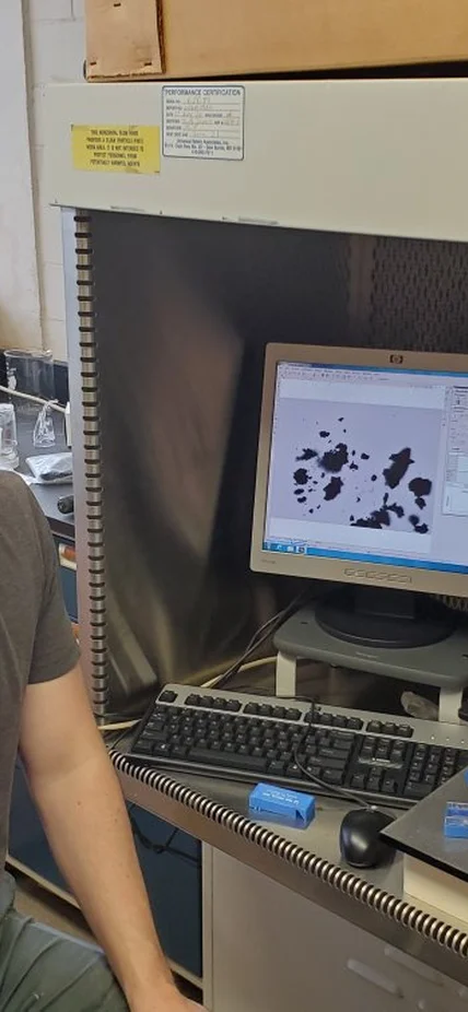 Jens Barosch studies a sample of the Ryugu meteorite under a microscope on campus.