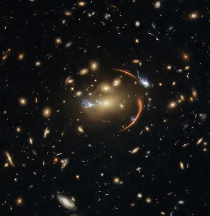 This Hubble image shows the galaxy cluster MACS J0138.0-2155, which is so massive that its gravity bent and magnified light streaming not only from an extremely distant background galaxy but also from a supernova event in this galaxy. The color image was made using observations from eight different filters spread across Hubble’s Advanced Camera for Surveys (ACS) and Wide Field Camera 3 (WFC3). The color results from assigning different hues to each monochromatic image associated with an individual filter. I
