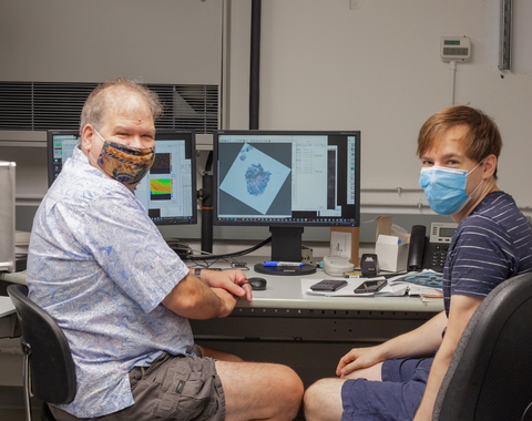 Larry Nittler and Jens Barosch pose for a photo as they scan a sample of the Ryugu asteroid