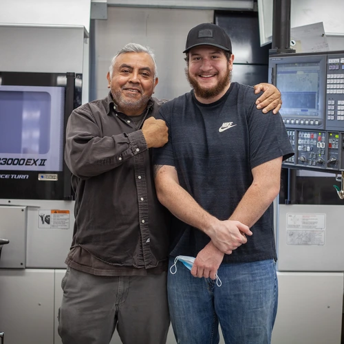 Victor Lugo and Seth Wagner Hug in Machine Shop